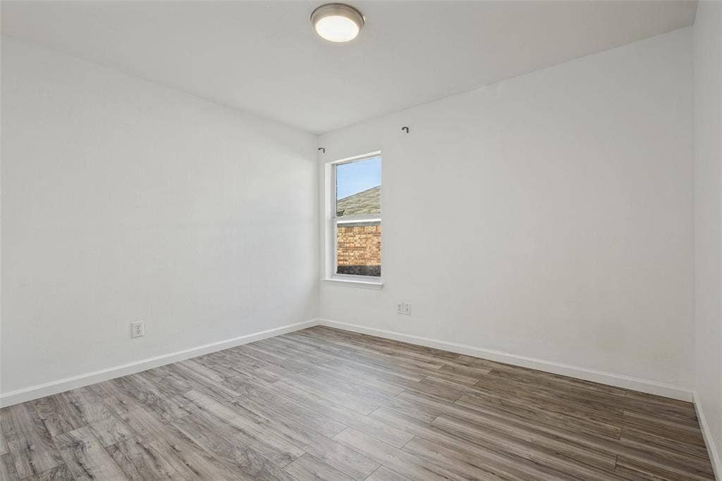2405 Collier Drive, McKinney, TX 75071 Neutral wall tones with a single window and wood-finish flooring