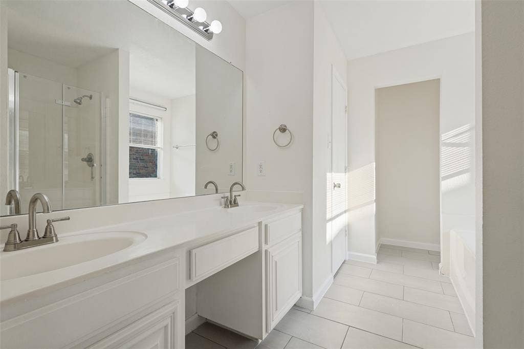 2405 Collier Drive, McKinney, TX 75071 Dual sink vanity with white cabinetry, brushed nickel fixtures, a large wall-mounted mirror, and tile flooring
