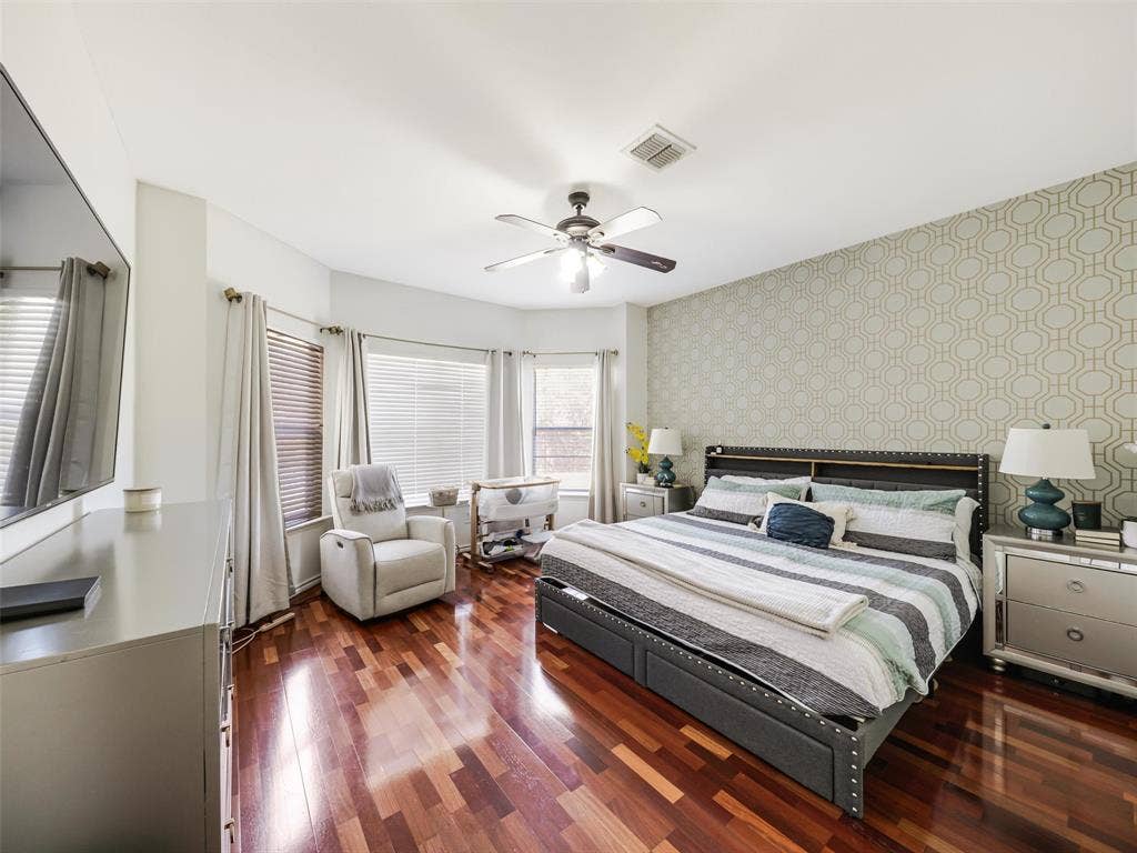 1206 Bel Air Drive, Allen, TX 75013 Hardwood flooring, bay window with blinds, ceiling fan, and accent wall