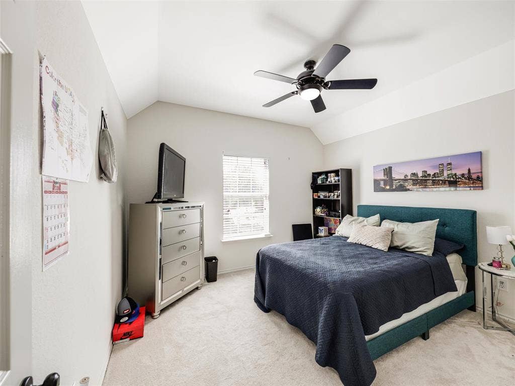 1206 Bel Air Drive, Allen, TX 75013 Vaulted ceiling with a black ceiling fan, light-colored walls, window with blinds, and light carpet flooring