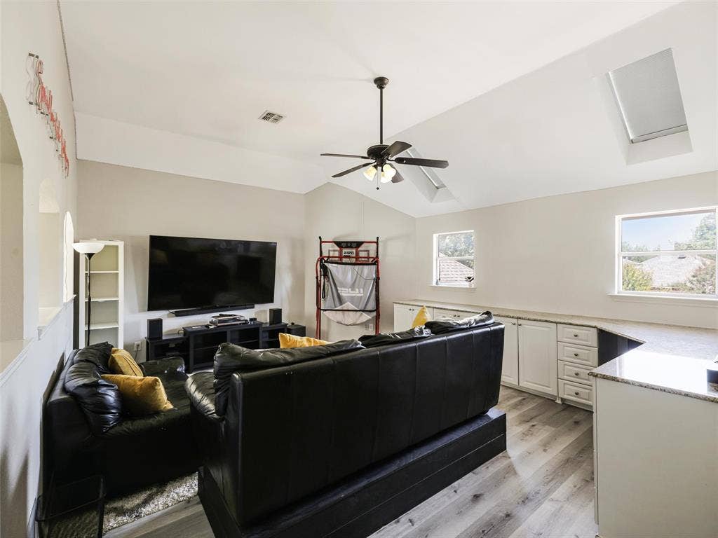 1206 Bel Air Drive, Allen, TX 75013 Vaulted ceiling with skylight, wood-finish flooring, ceiling fan, built-in cabinetry, and integrated countertop