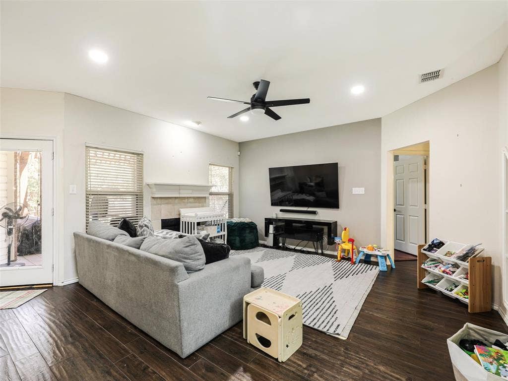 1206 Bel Air Drive, Allen, TX 75013 Vaulted ceiling with recessed lighting, wood-finish flooring, and a fireplace with a stone surround