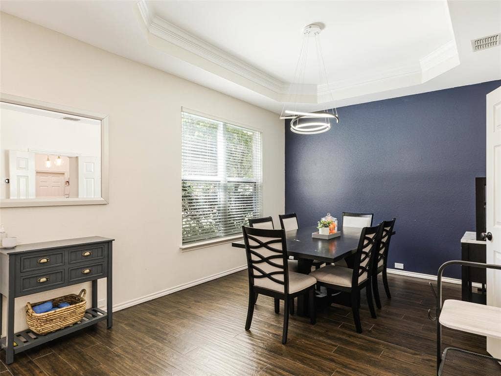 1206 Bel Air Drive, Allen, TX 75013 Wood-finish flooring throughout, tray ceiling with crown molding, contemporary chandelier, and a window with blinds