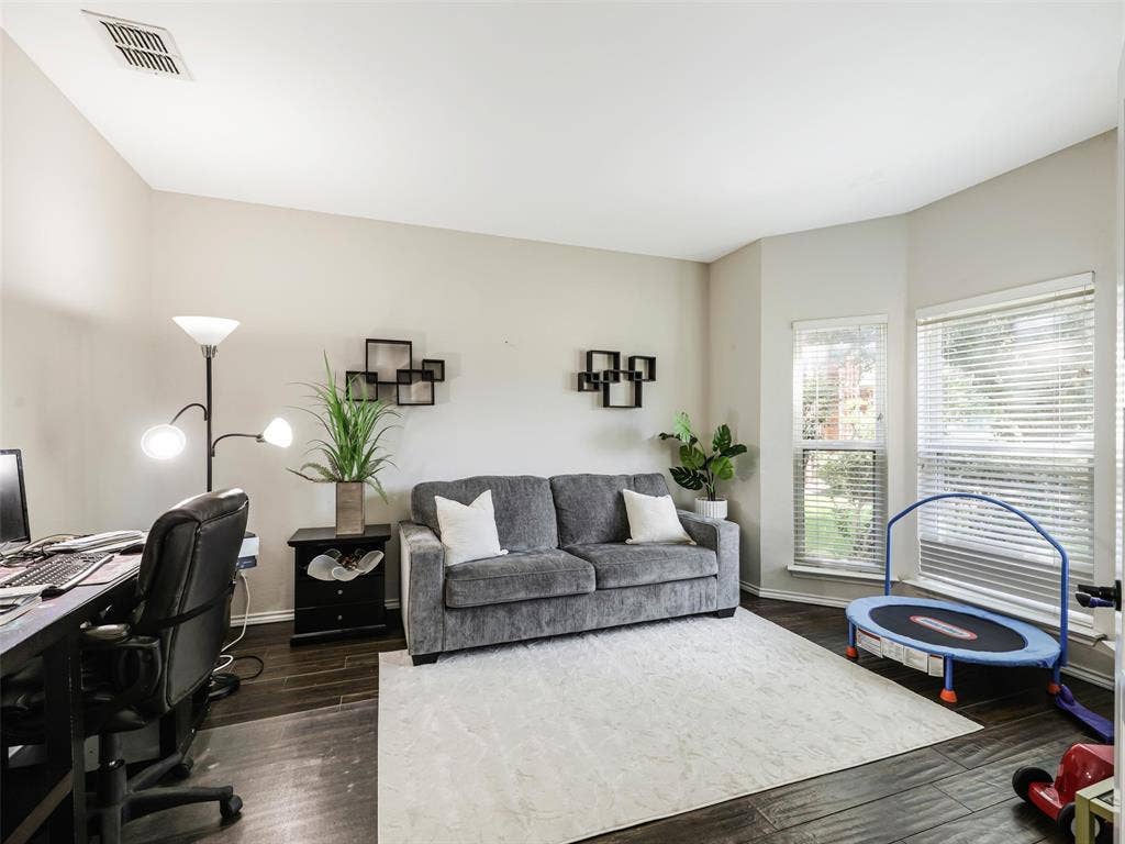 1206 Bel Air Drive, Allen, TX 75013 Room featuring wood-finish flooring, two window openings, and neutral wall tones