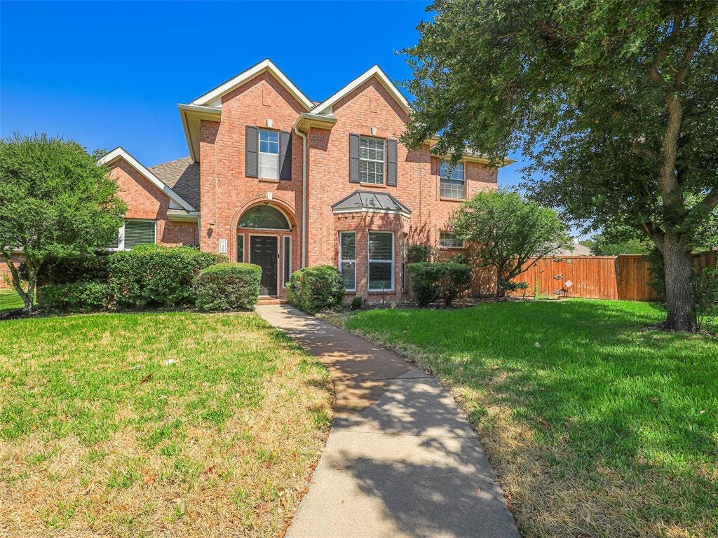 1206 Bel Air Drive, Allen, TX 75013 Brick exterior with multiple gables, arched entry, black paneled shutters, and established landscaping