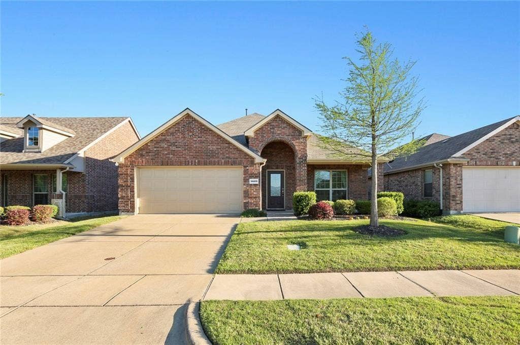 9609 Sand Trap Drive, McKinney, TX 75072 Brick exterior, attached two-car garage, concrete driveway, front yard landscaping, and a covered entry