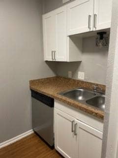 2200 W Lowden Street, #22, Fort Worth, TX 76110 White shaker-style cabinetry, stainless steel double basin sink, speckled countertop, wood-finish flooring, and a stainless steel dishwasher