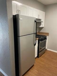 2200 W Lowden Street, #22, Fort Worth, TX 76110 Stainless steel refrigerator, stainless steel range, white cabinetry, wood-finish flooring, and light-toned countertops