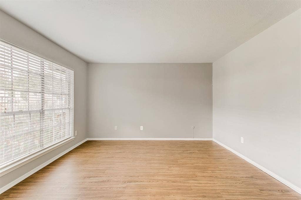 2200 W Lowden Street, #22, Fort Worth, TX 76110 Wood-finish flooring, neutral wall tones, and a large window with blinds