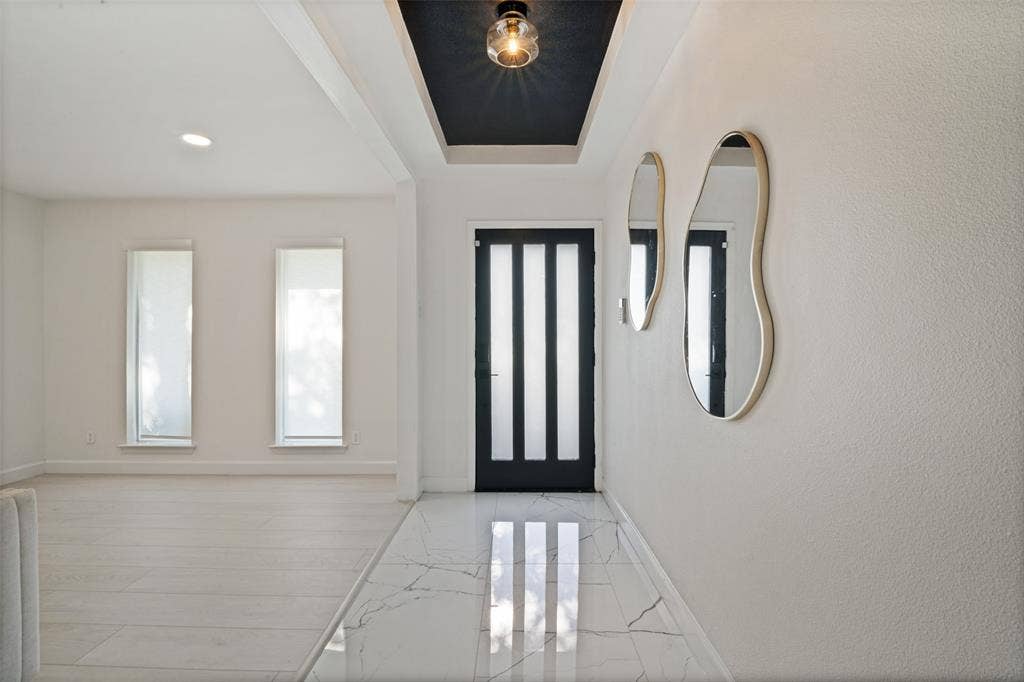 5021 Ashbrook Road, Dallas, TX 75227 Recessed ceiling lighting, a dark contrasting ceiling accent, and a modern entry door with vertical light panels