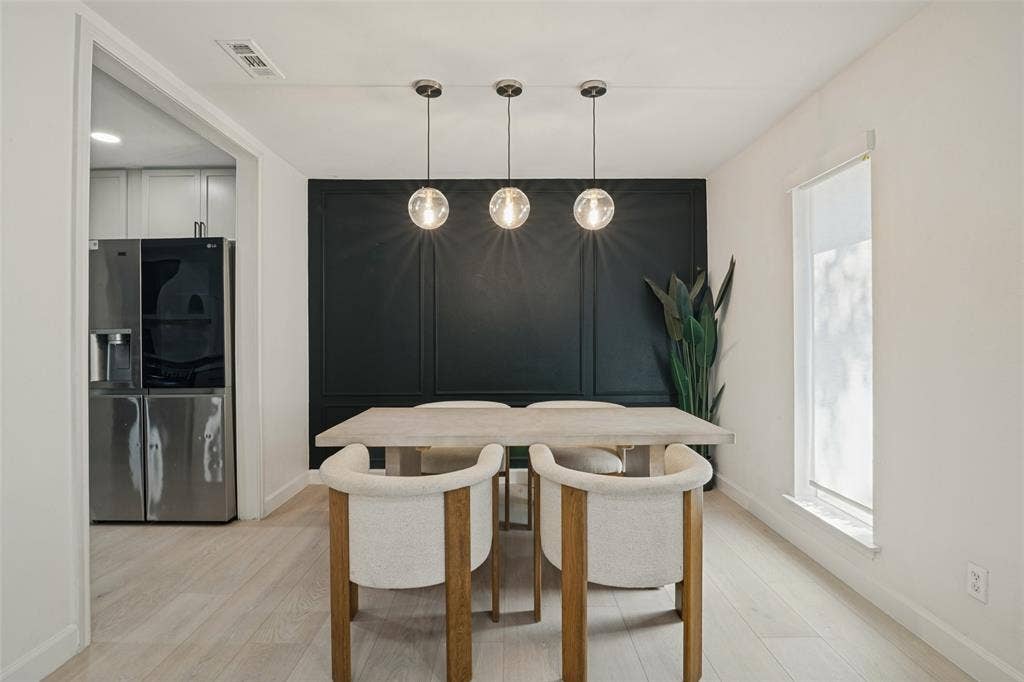 5021 Ashbrook Road, Dallas, TX 75227 Wood-finish flooring, accent wall with decorative paneling, recessed lighting, and three globe pendant light fixtures