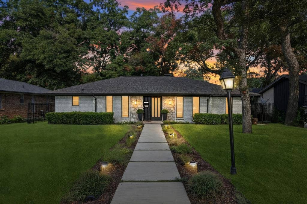 5021 Ashbrook Road, Dallas, TX 75227 Modern ranch-style residence featuring a dark shingle roof, stone and stucco exterior, and a concrete paver walkway