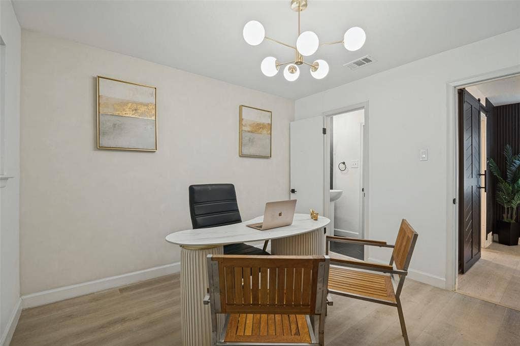 5021 Ashbrook Road, Dallas, TX 75227 Modern chandelier, light wood-finish flooring, white walls, and dark wood barn door