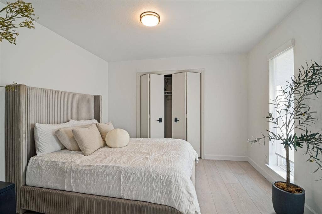 5021 Ashbrook Road, Dallas, TX 75227 Light wood-finish flooring, white walls, flush-mount ceiling light, white bi-fold closet doors, and large window