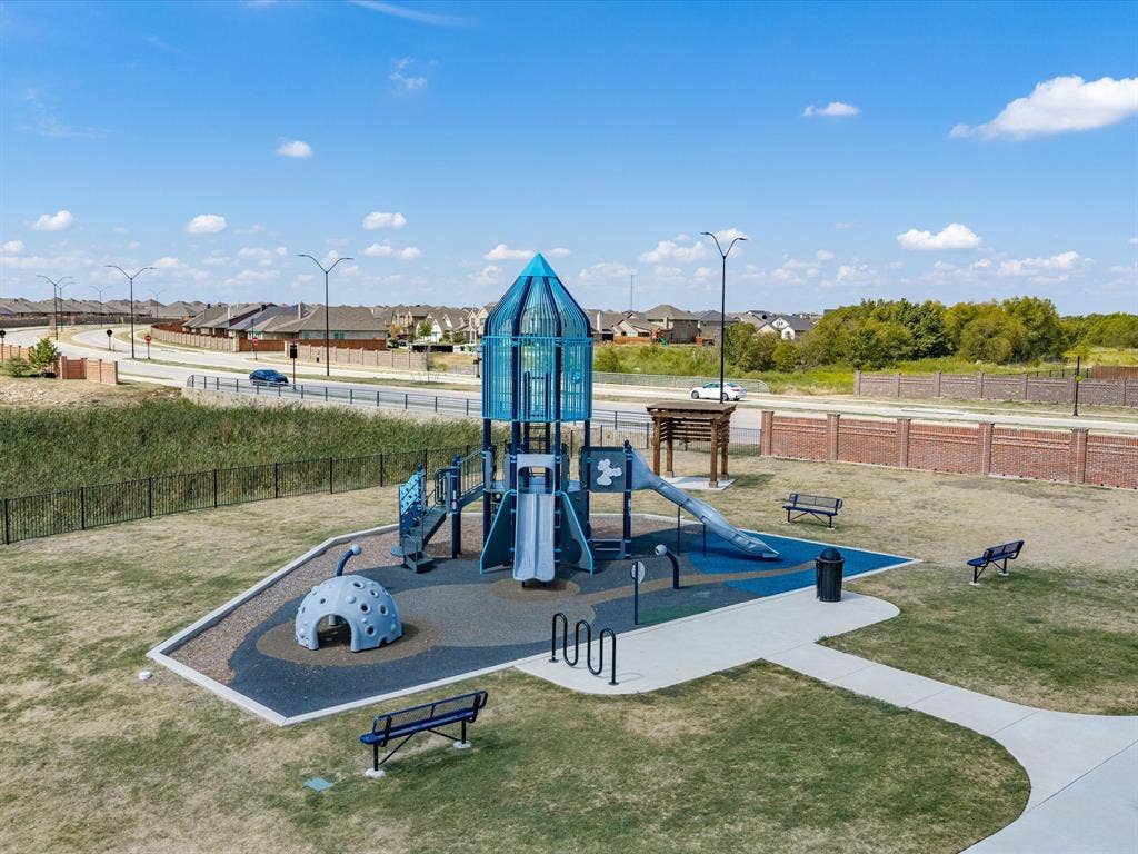 Playground area featuring a rocket-themed play structure, multiple slides, and a gray domed climber
