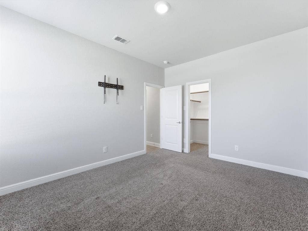 Carpeted flooring, recessed lighting, white interior doors, and a built-in wall mount