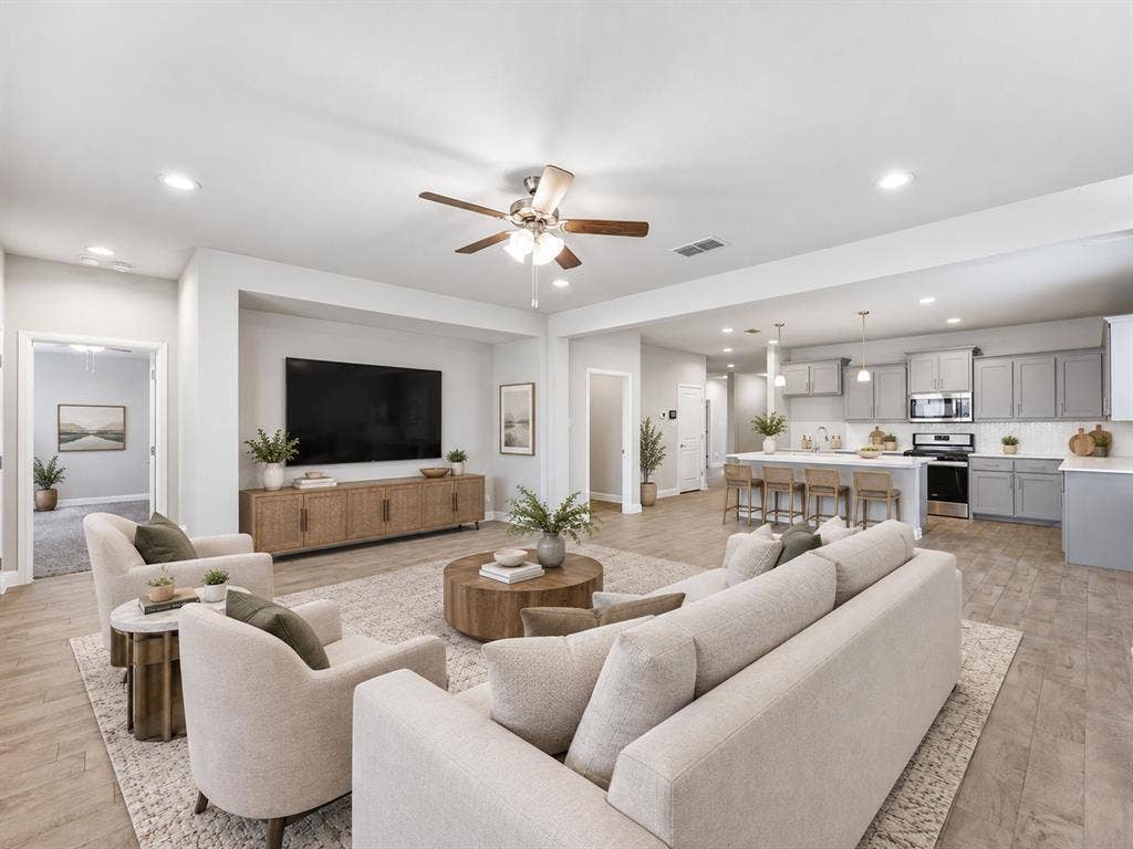 Open-concept living space featuring wood-finish flooring, recessed lighting, and a ceiling fan