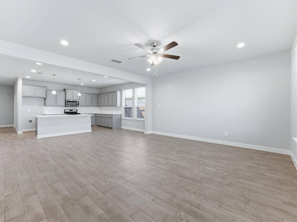 Open concept living area with wood-finish flooring, recessed lighting, and a ceiling fan
