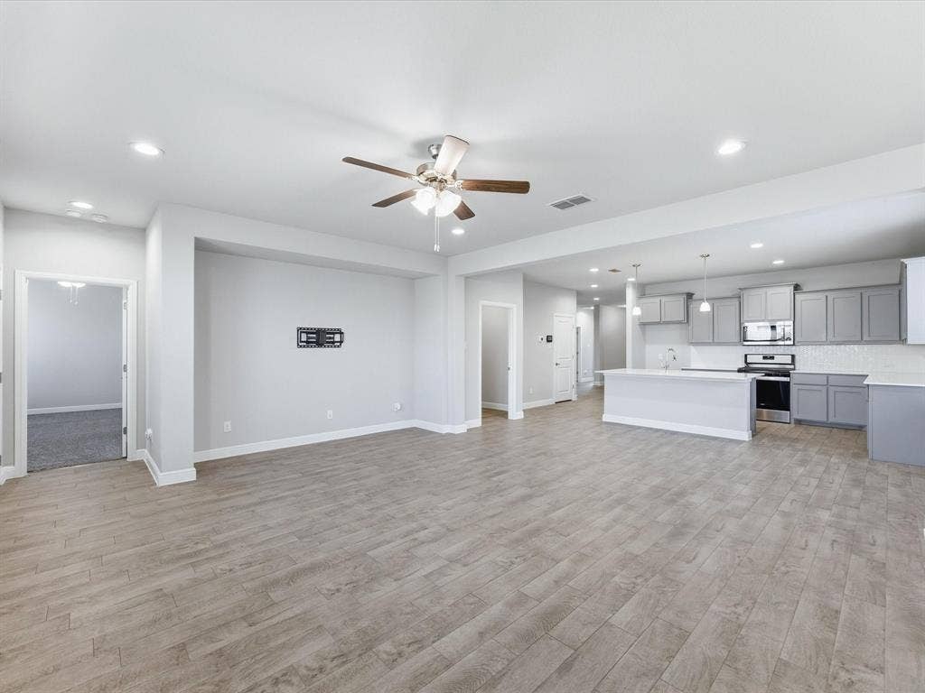 Open-concept living space with wood-finish flooring, recessed lighting, and a ceiling fan