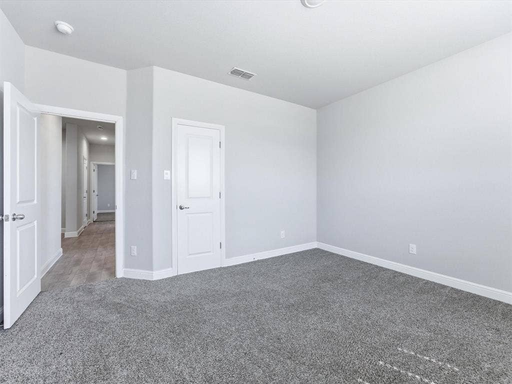 Neutral wall paint, gray carpeting, white trim, recessed lighting, and white panel doors
