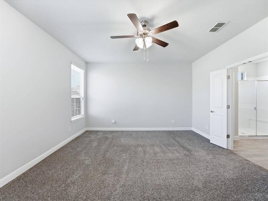 Expansive room with neutral carpet flooring and white walls