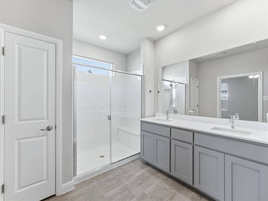 Dual vanity with gray cabinetry, white countertops, and undermount sinks