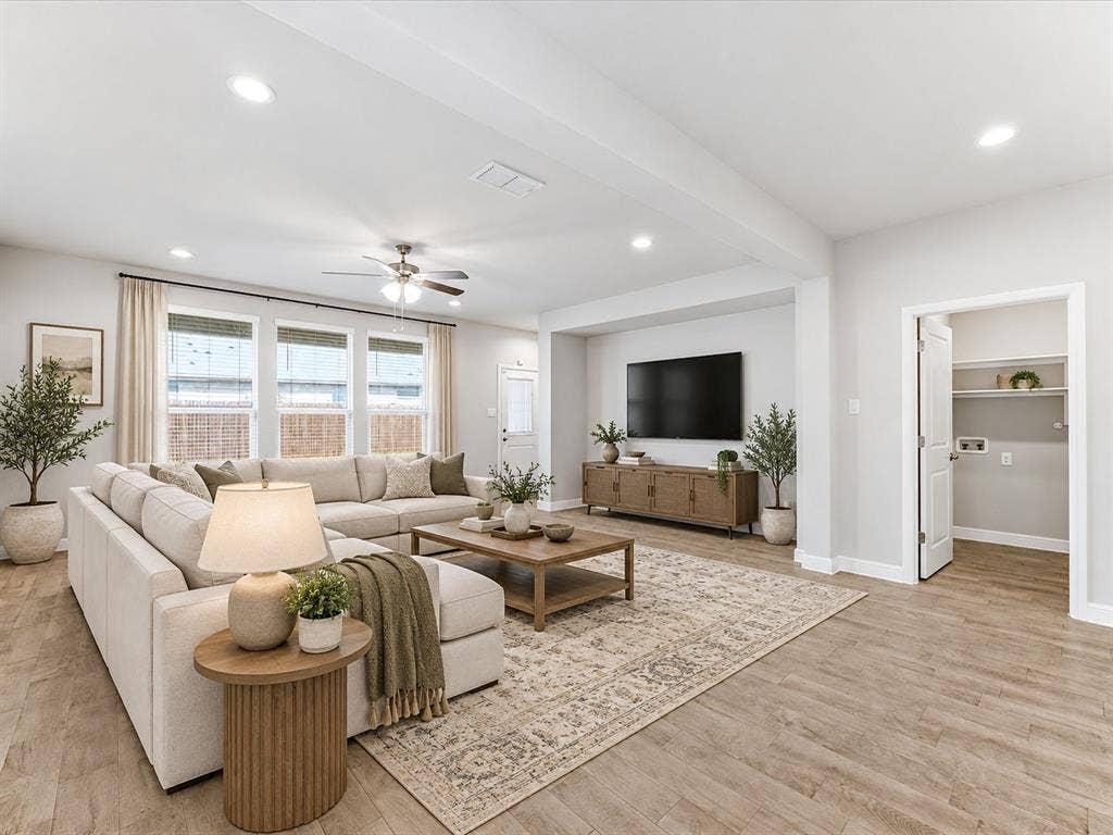 Recessed lighting throughout, ceiling fan, multiple windows with blinds, wood-finish flooring, and a laundry closet with shelving