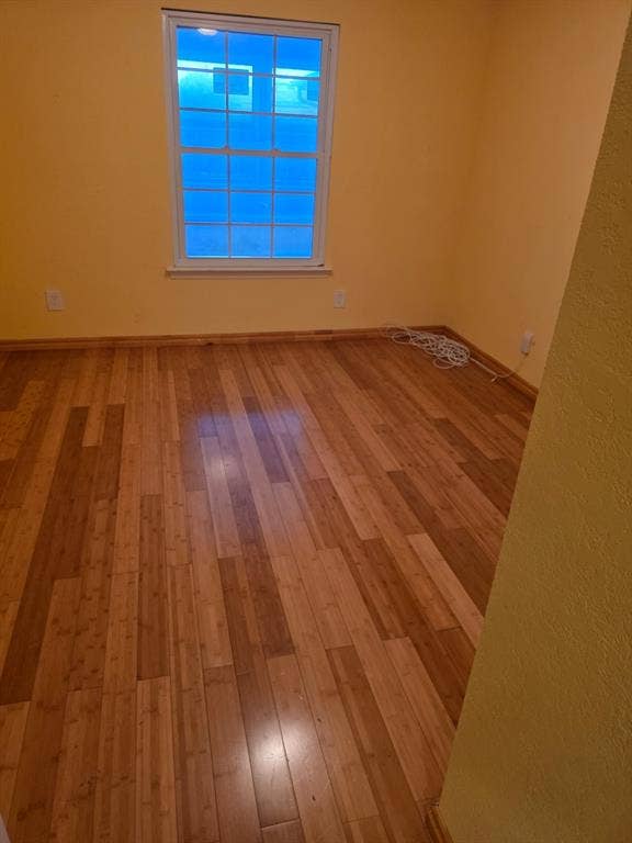 1608 University Drive, Richardson, TX 75081 Spare room featuring baseboards and hardwood / wood-style flooring