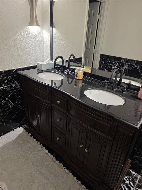 1608 University Drive, Richardson, TX 75081 Full bathroom with marble finish floor, double vanity, a sink, and a textured wall