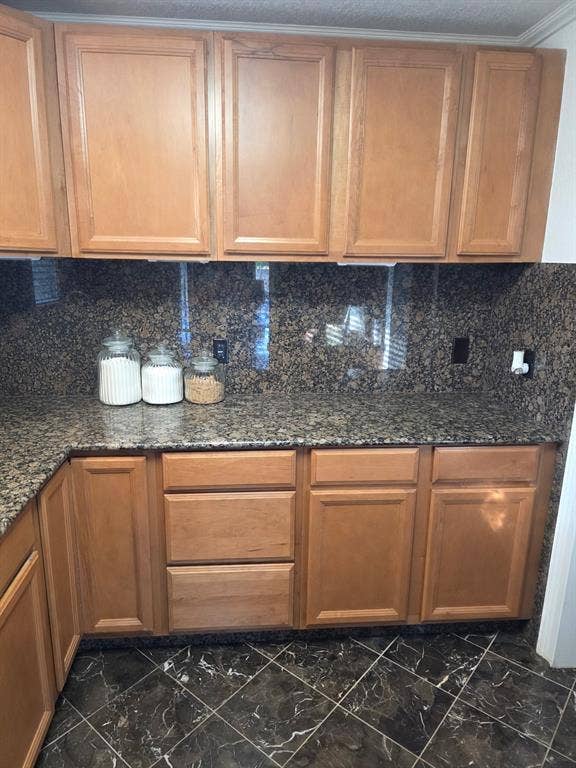 1608 University Drive, Richardson, TX 75081 Kitchen featuring marble finish floor, dark stone counters, and decorative backsplash