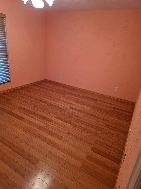 1608 University Drive, Richardson, TX 75081 Unfurnished room featuring hardwood / wood-style floors and a chandelier