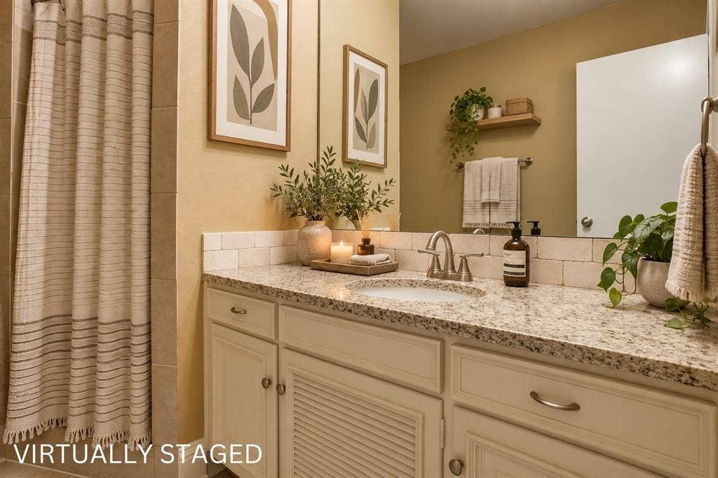 Vanity with a light-toned granite countertop, undermount sink, and brushed nickel faucet