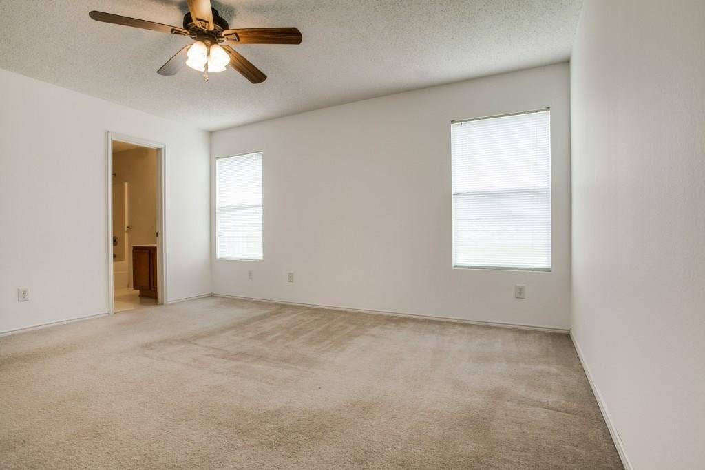 2800 Bissell Way, Wylie, TX 75098 Spacious room with two windows, a ceiling fan with integrated lighting, and neutral-toned carpeting