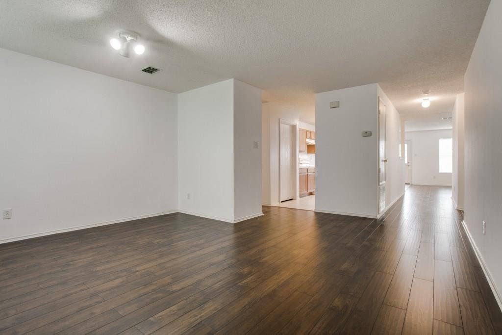 2800 Bissell Way, Wylie, TX 75098 Spacious room with dark wood-finish flooring, white walls, and a track lighting fixture