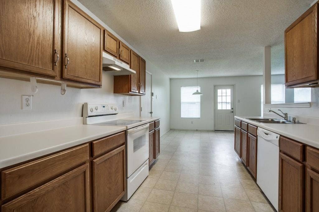 2800 Bissell Way, Wylie, TX 75098 Kitchen featuring wood-finish cabinetry, white countertops, a white electric range, and a white dishwasher