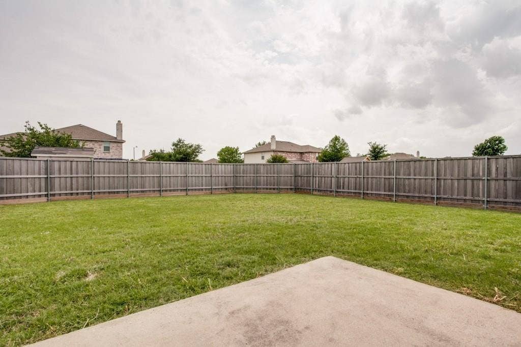 2800 Bissell Way, Wylie, TX 75098 Expansive backyard featuring a manicured lawn, a full wood fence, and a concrete patio