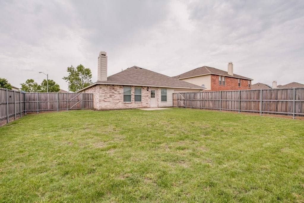 2800 Bissell Way, Wylie, TX 75098 Expansive backyard featuring a privacy fence, brick exterior, and a chimney