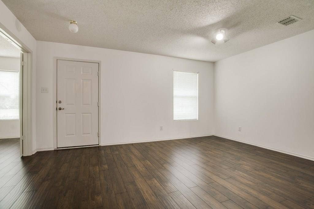 2800 Bissell Way, Wylie, TX 75098 Wood-finish flooring, white walls, paneled door, ceiling-mounted lighting, and window with blinds