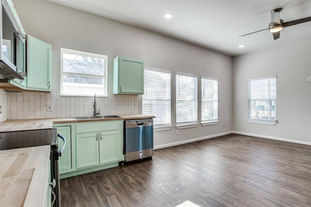 2316 Marburg Street, Dallas, TX 75215 Kitchen featuring wooden counters, stainless steel appliances, tasteful backsplash, a sink, and green cabinetry