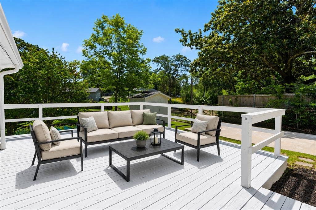110 Henderson Harbor Circle, Payne Springs, TX 75156 Spacious outdoor deck with white railing, featuring a solid surface, and surrounded by mature trees