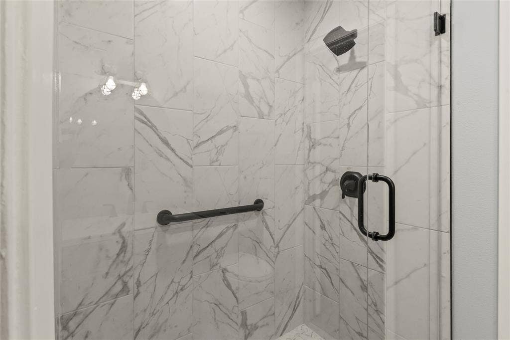110 Henderson Harbor Circle, Payne Springs, TX 75156 Shower with large format marble-look tile, matte black fixtures, and a glass enclosure
