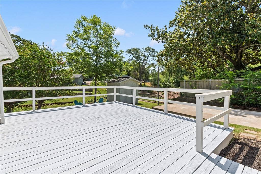 110 Henderson Harbor Circle, Payne Springs, TX 75156 Expansive wooden deck with white railing, overlooking a lush green yard with mature trees