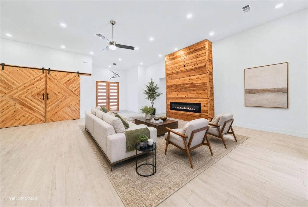 Wood-finish flooring throughout, featuring a natural wood accent wall with an integrated linear fireplace