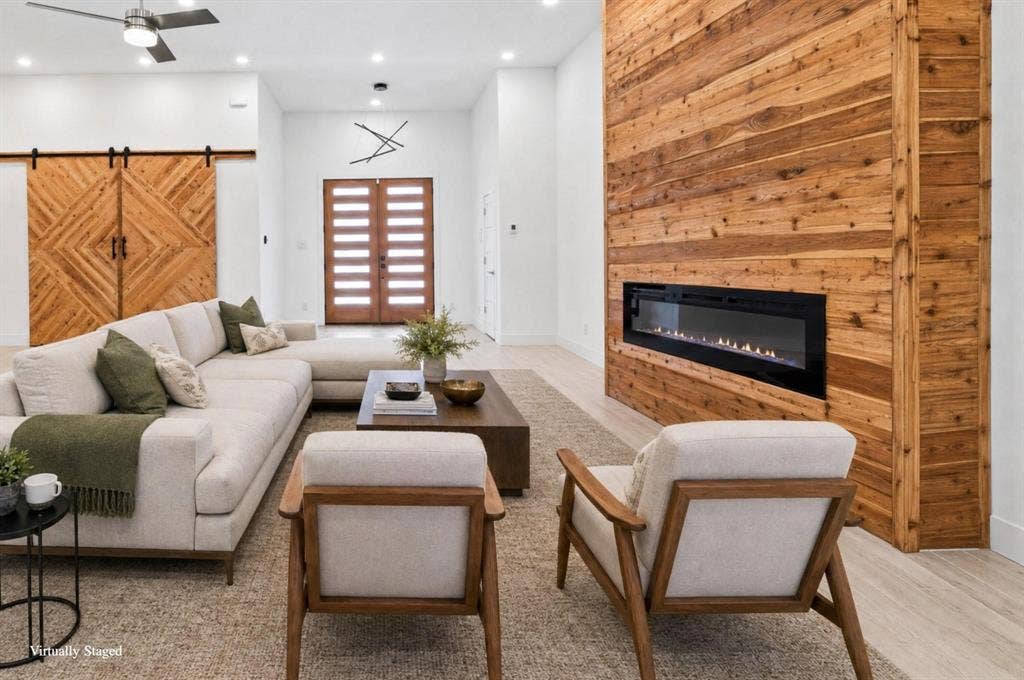 Integrated linear fireplace with a wood-paneled accent wall, wood-finish flooring, recessed lighting, and a modern ceiling fan