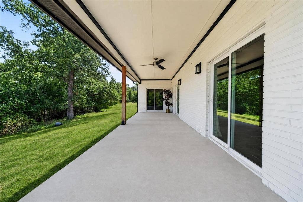 Expansive covered patio featuring a ceiling fan, recessed lighting, and multiple sliding glass doors