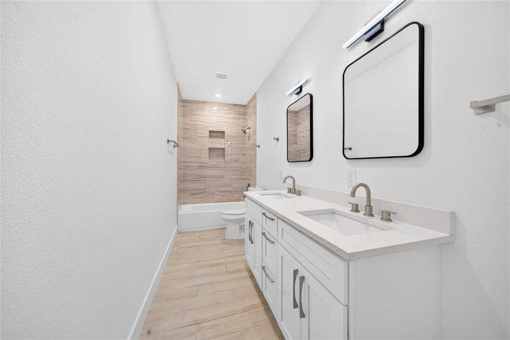 Dual vanity with undermount sinks, stone countertops, and brushed nickel fixtures