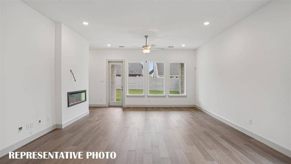 3417 Pickerel Point, McKinney, TX 75071 Featuring a wall of windows overlooking the back yard, this family room is where memories will be made! REPRESENTATIVE PHOTO