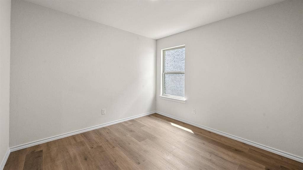 810 Parksville Drive, Ferris, TX 75125 Wood-finish flooring with white trim and a single window