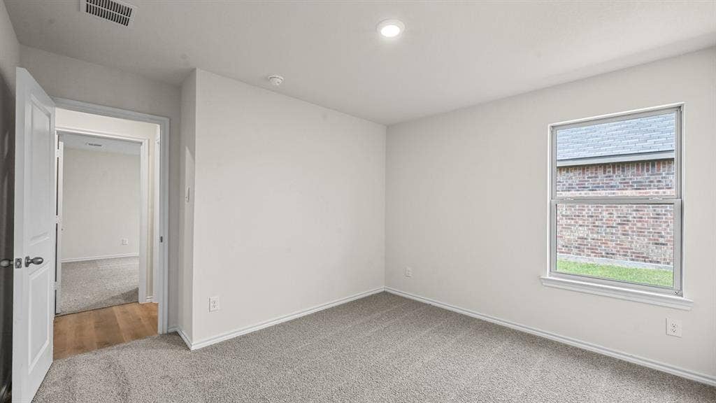 810 Parksville Drive, Ferris, TX 75125 Recessed ceiling lighting, light-colored walls, carpeted flooring, wood-finish flooring in doorway, window with exterior brick detail