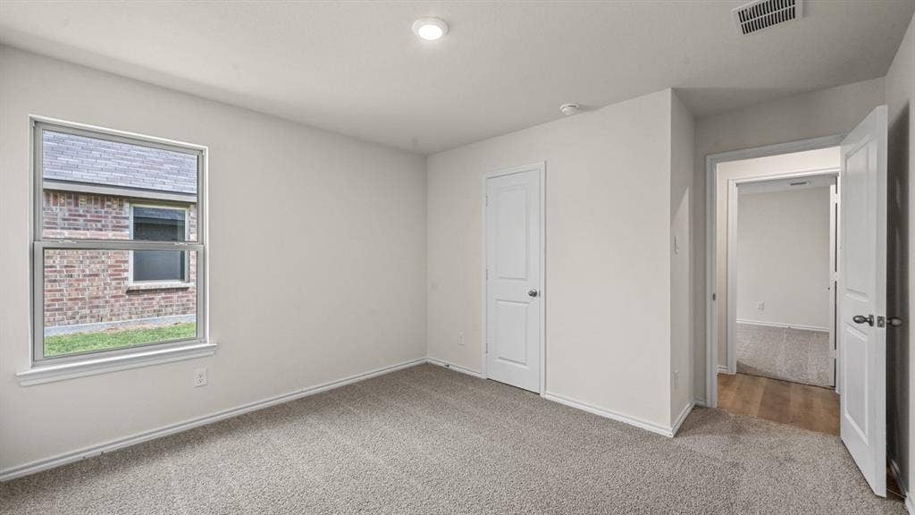 810 Parksville Drive, Ferris, TX 75125 Neutral wall paint, recessed ceiling lighting, textured carpeting, white trim, and a window with exterior brick detail